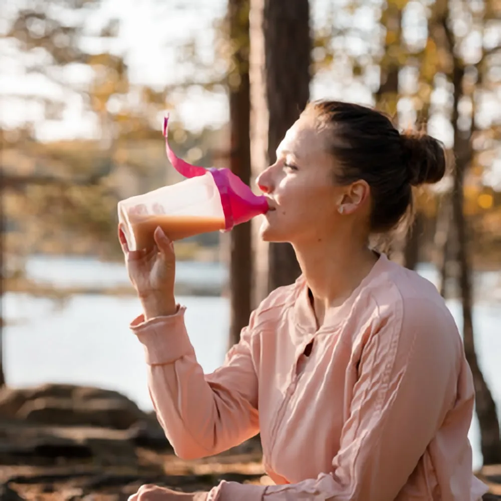 Drinking a Shake SkinnyBox woman drinking a SkinnyBox shake in an outdoor setting